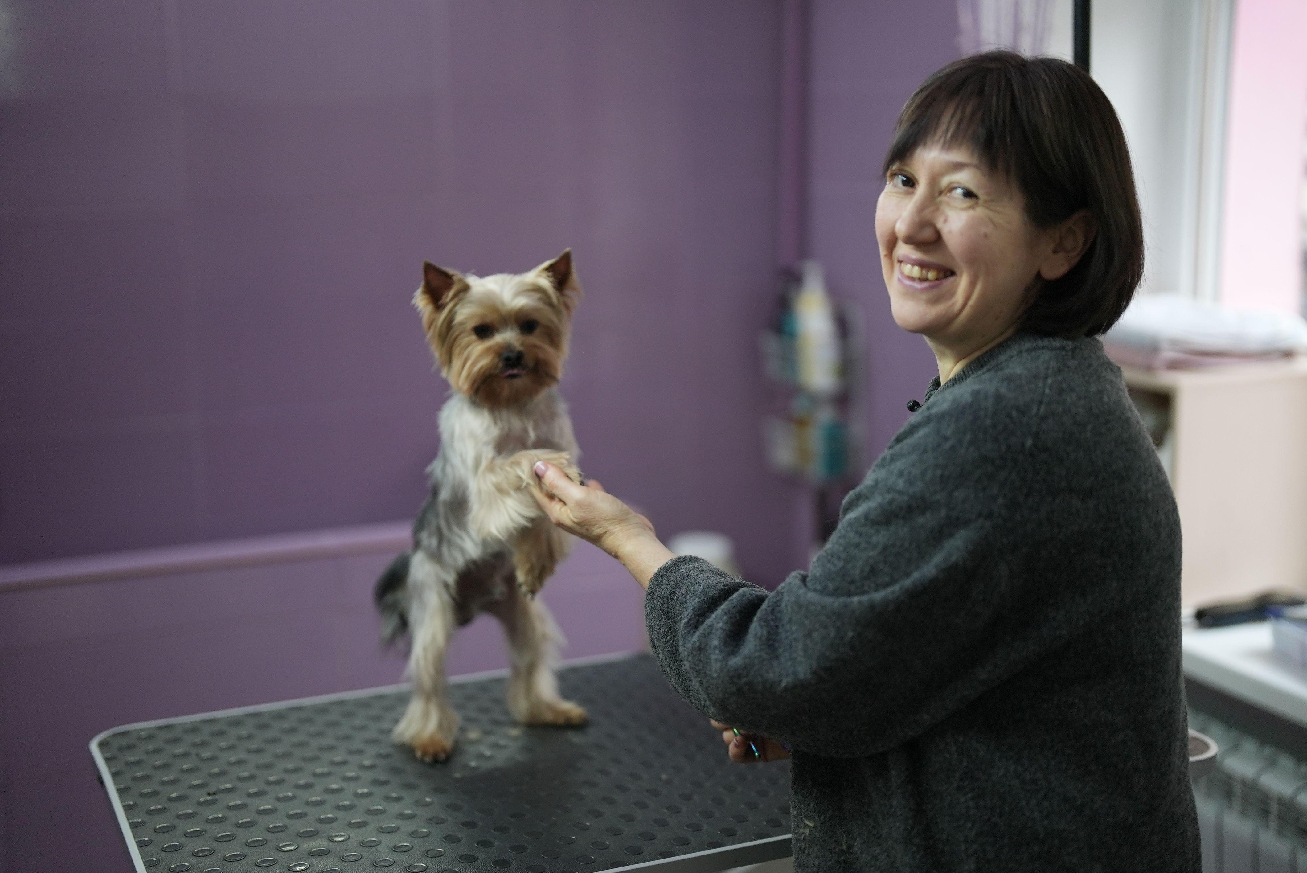 Žena drži psa za prednje šape