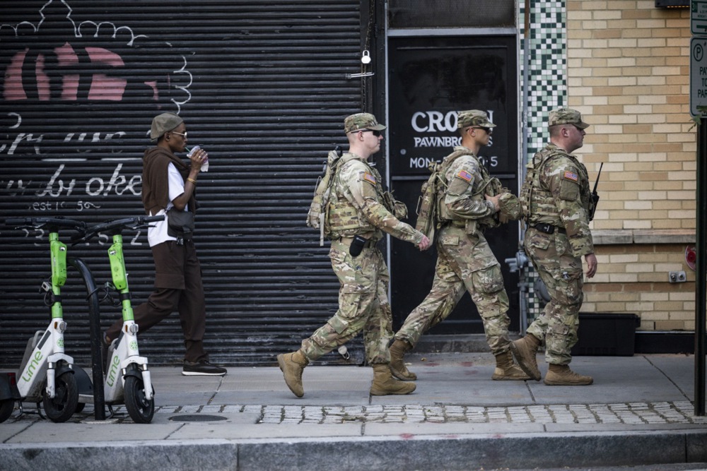 epa12319265 National Guard troops march on the sidewalk of the Scott Circle neighborhood in Washington, DC, USA, 23 August 2025. The nearly 2,300 National Guard troops deployed from 6 states to Washington, DC now have law enforcement powers and are authorized to carry service weapons for personal protection. 