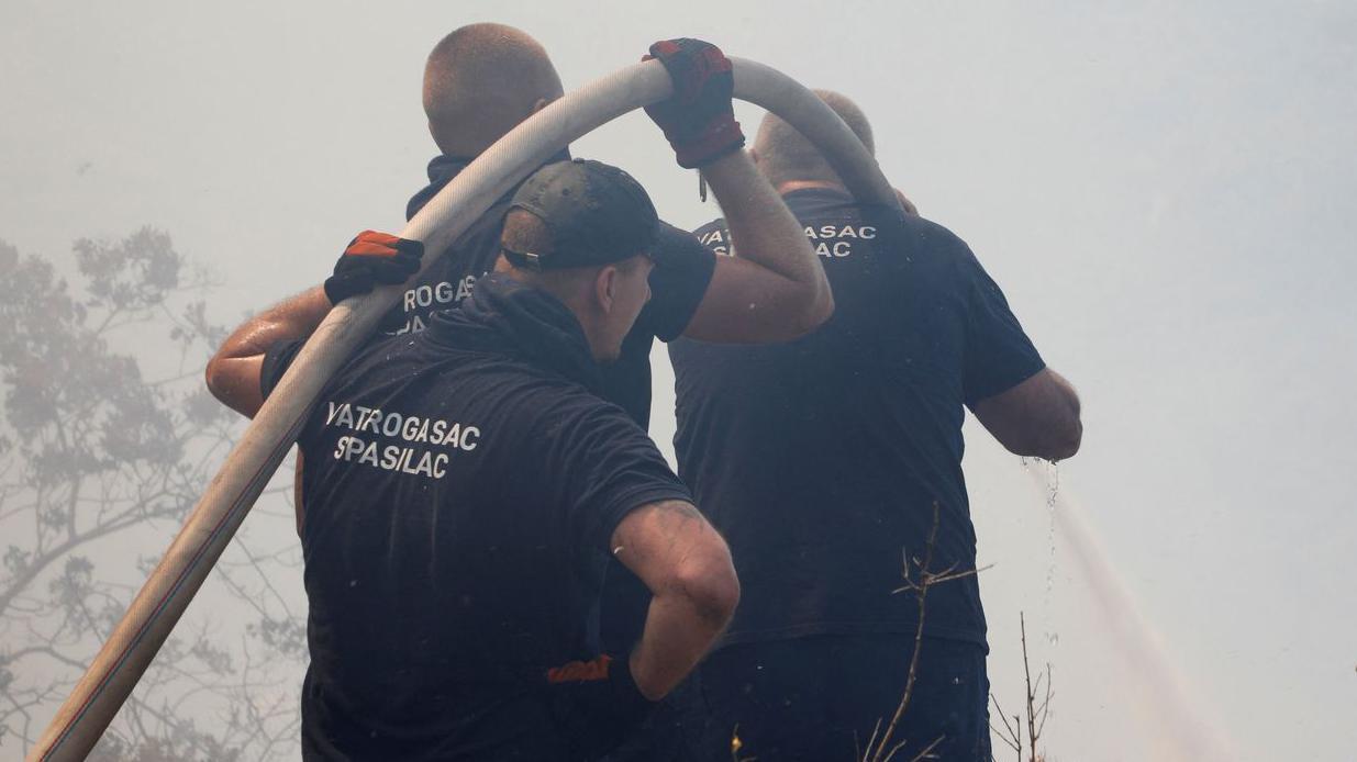 Dan žalosti u Crnoj Gori, nastavljena borba sa požarima 15 Trojica vatrogasaca drže crevo i pokušavaju da ugase vatru