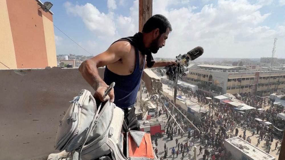 Izraelski napad na bolnicu u Gazi - šta znamo do sada 1 Čovek drži opremu ubijenog palestinskog snimatelja Husama al-Masrija na balkonu bolnice