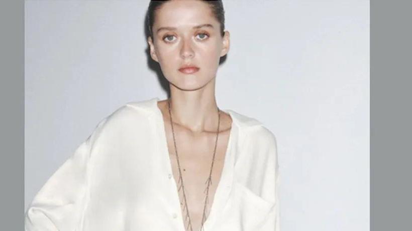 Devojka u beloj košulji sa dubokim izrazom