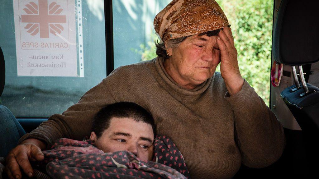 Kako se deca sa invaliditetom nose sa ratom u Ukrajini 4 Majka plače uz sina koji leži i pokriven je ćebetom u Bahmutu