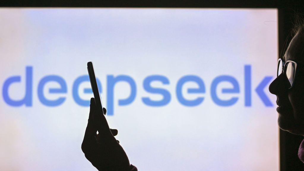 Kako veštačka inteligencija pruža emotivnu podršku mladima 3 A woman holds a cell phone in front of a computer screen displaying the DeepSeek logo