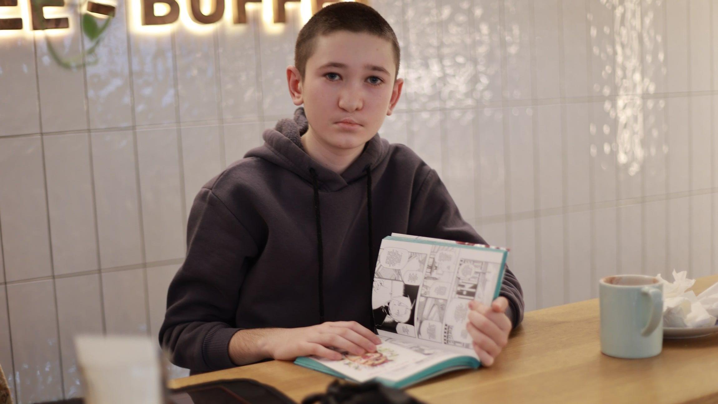 Kako se deca sa invaliditetom nose sa ratom u Ukrajini 6 Nazar Gutnik drži knjigu i gleda u kameru