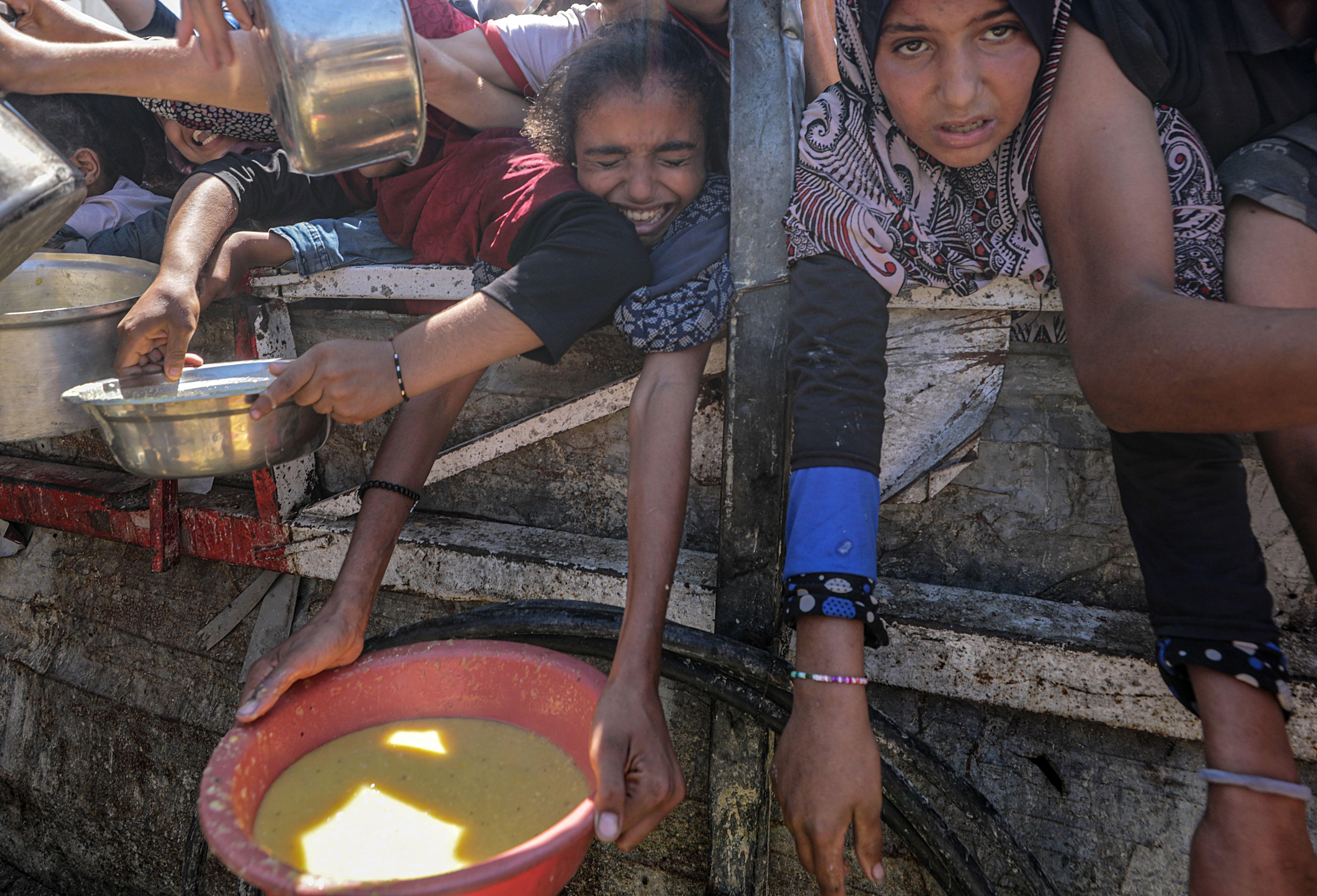Gaza posle rata... Ko će se nositi sa 'bezbednosnom noćnom morom' 11 Interno raseljeni Palestinci i mala deca, drže lonce dok dobijaju hranu iz dobrotvorne kuhinje u gradu Gazi 4. avgusta 2025.