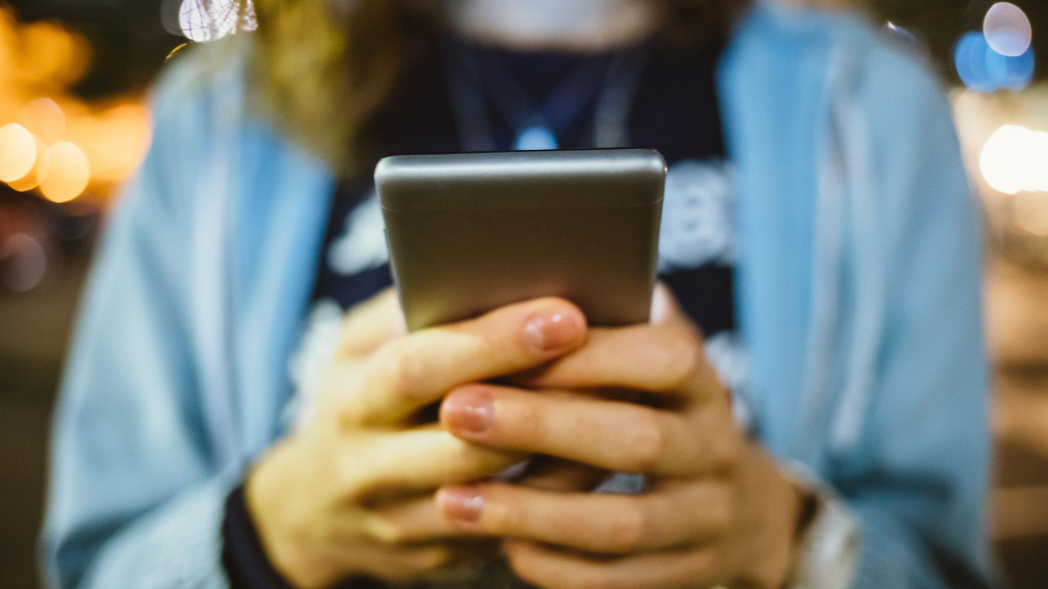 Aplikacija za bezbedan dejting koja to nije: 'Delili su moju adresu i ponižavali me' 1 žena drži telefon