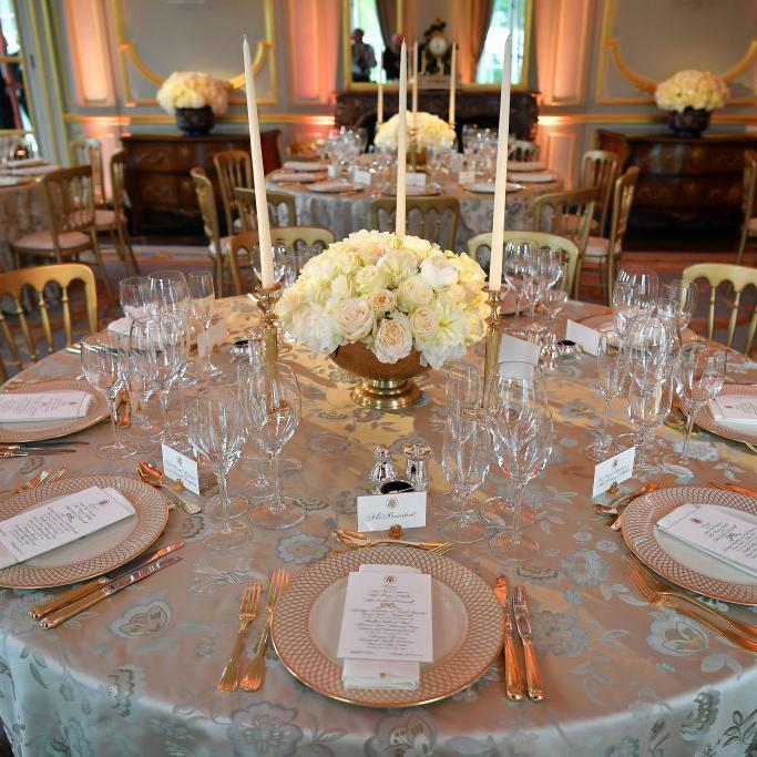 postavljeni stolovi sa luksuznim escajgom i belim ružama u sredini 