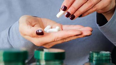 Da li svi treba da uzimamo vitaminske suplemente 1 Šaka devojke puna tableta, ženska ruka puna tableta