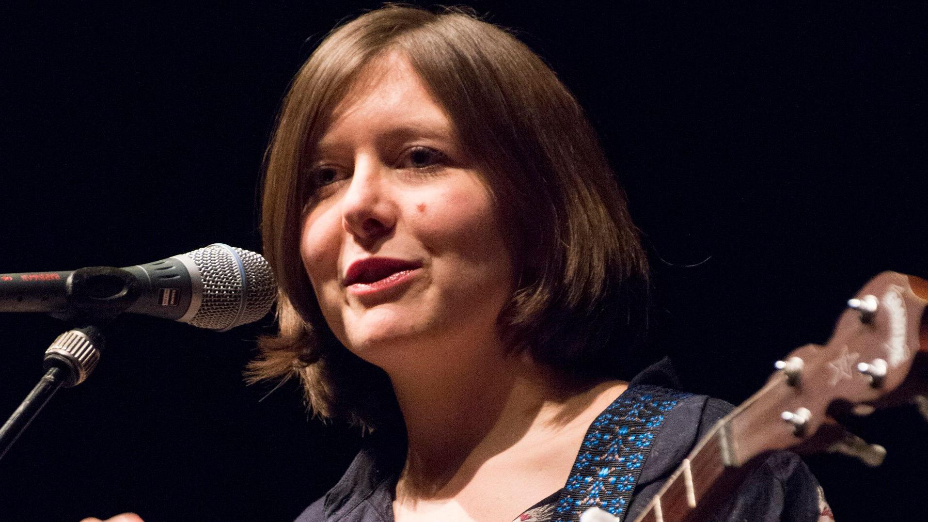 Obožavaoci su ludi za njenim novim albumom, samo što ga ona nije snimila 1 Emili Portman sa gitarom i mikrofonom na bini