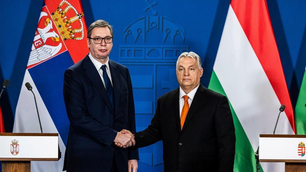 Da li Evropska unija menja stav prema Srbiji 4 Vučić i Orban u odelima se rukuju smrknutih izraza lica sa zastavama Srbije i Mađarske u pozadini