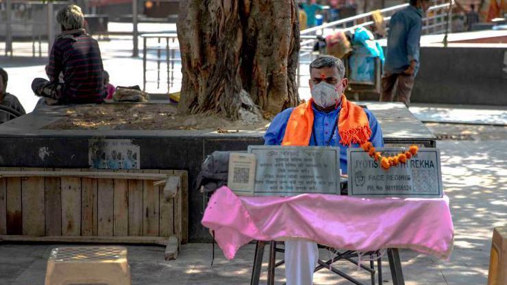 Astrolozi se naširoko konsultuju u Indiji, indijac sedi na klupi