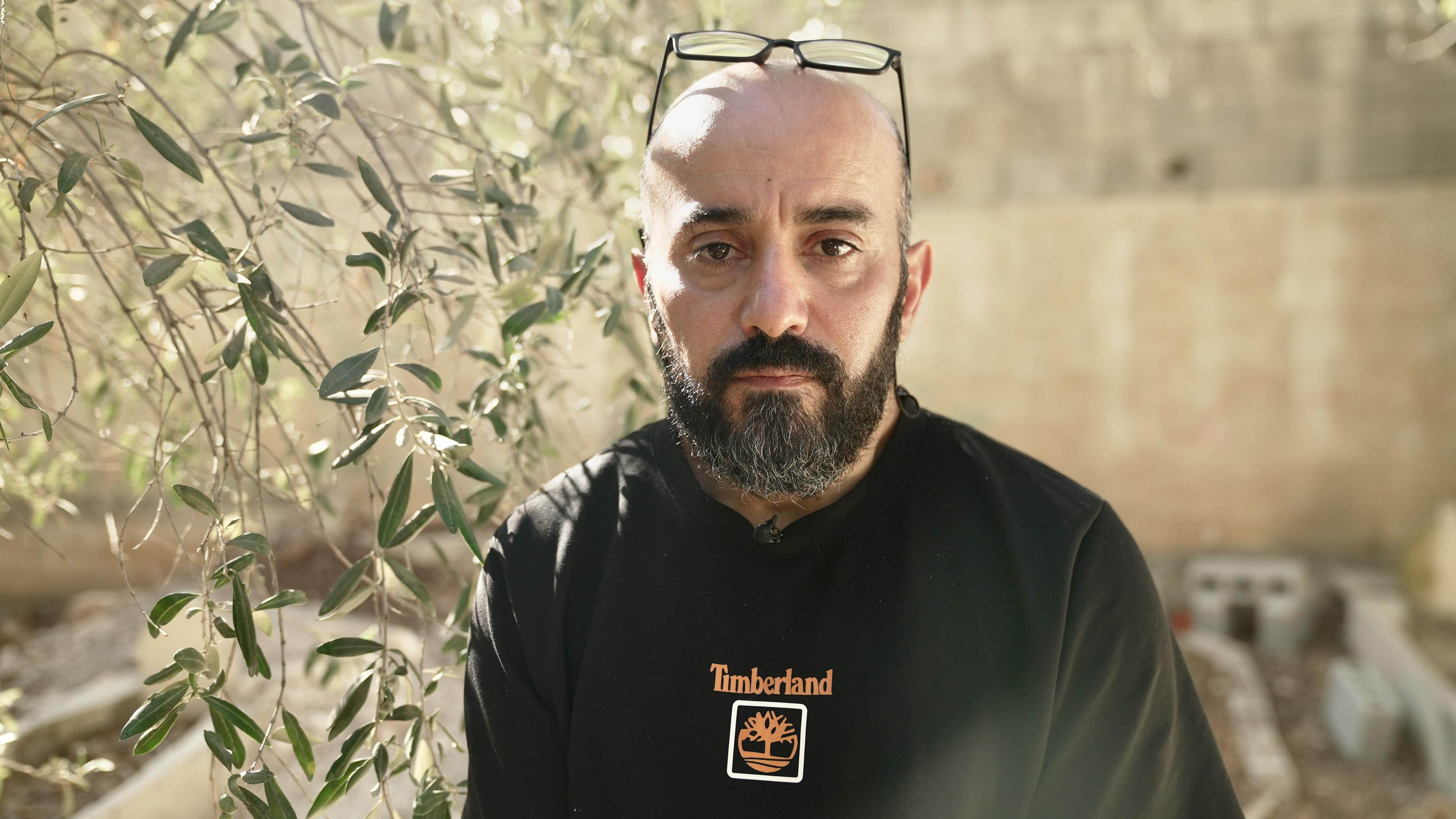 Muškarac u crnoj majici gleda u kameru