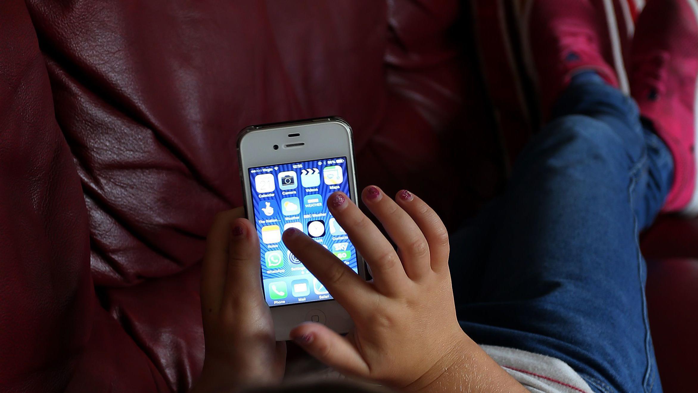 Dete i telefon, dete rukom pretražuje telefon, dete rukom traži aplikacije na telefonu