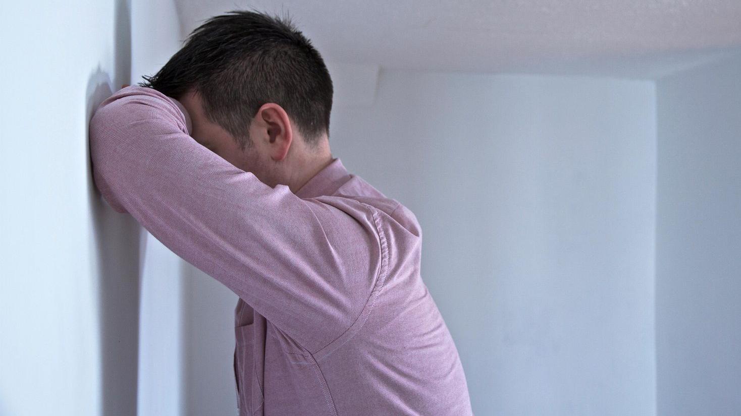 Opsesivno-kompulzivni poremećaj: Zarobljeni u mislima i ritualima 1 Čovek naslonjen na zid