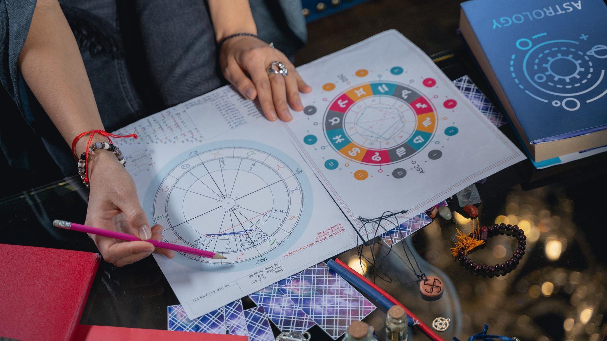 astrološka karta, žena gleda u astrološku kartu