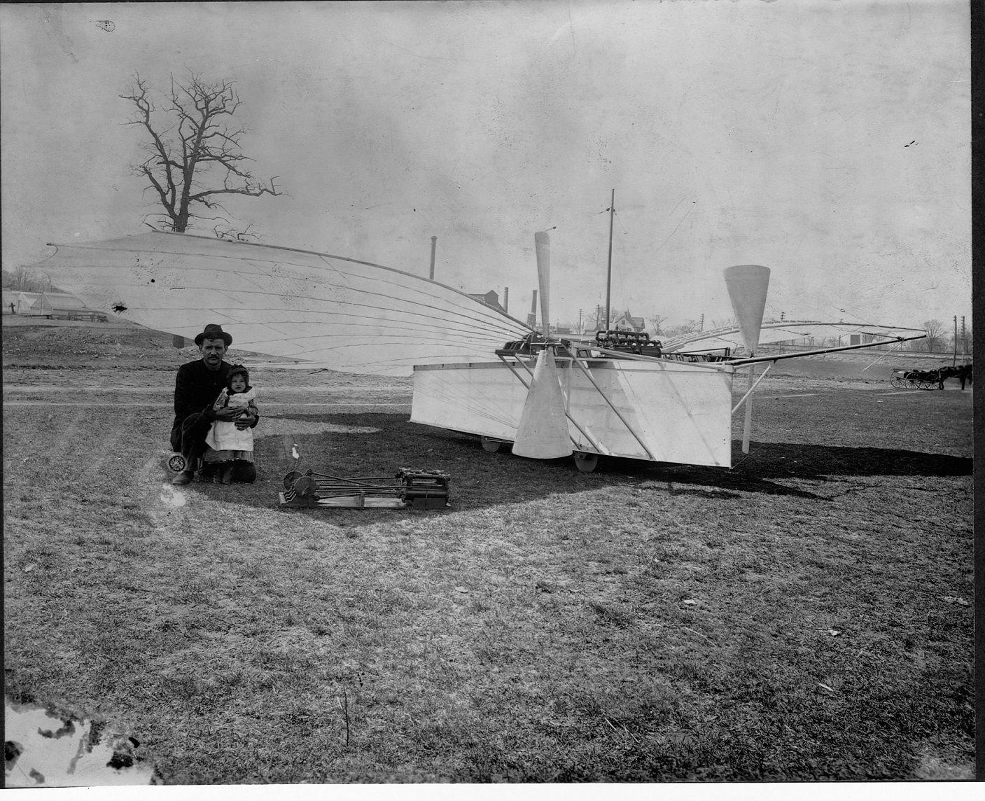 An old photograph of Gustav Weisskopf sitting next to an early plane model