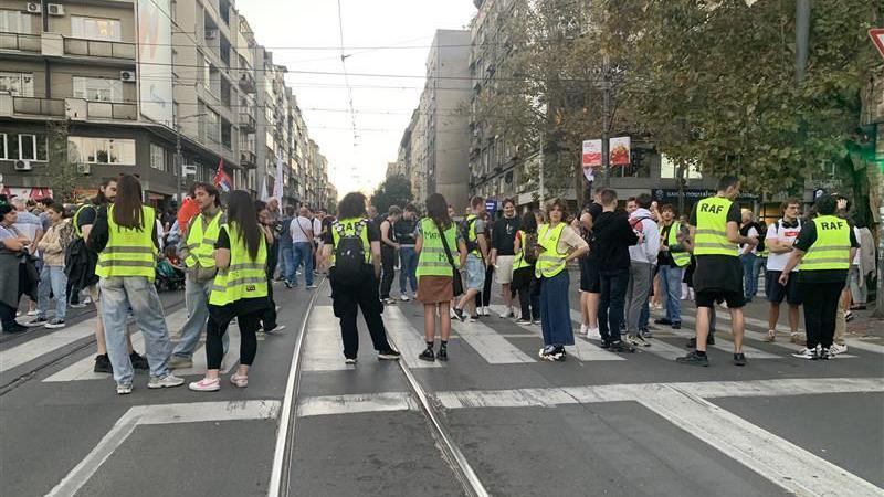 Grupa ljudi u žutim prslucima obezbeđuje protest ispred Pravnog fakulteta u Beogradu blokira saobraćajnicu 