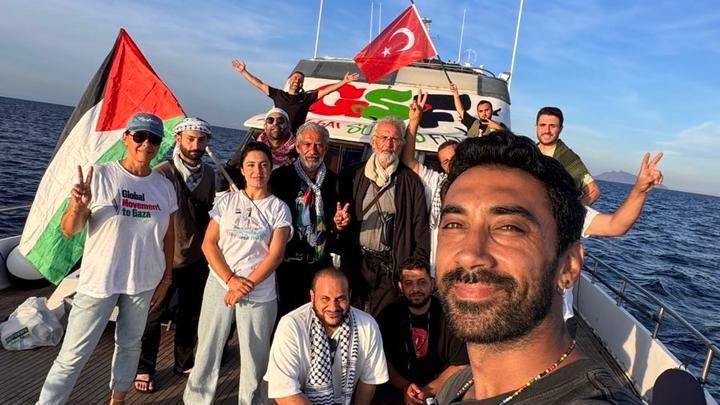 Šta je Sumud flotila i kolike su šanse da dopremi pomoć Gazi 1 Nasmejani čovek pravi selfi na brodu, dok u pozadini pozira još desetak ljudi. Vide se turska i palestinska zastava, kao i transparent GSF-a u bojama palestinske zastave.