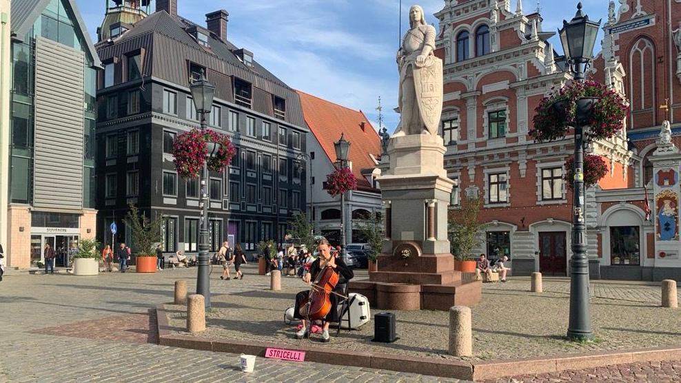 Devojka svira violončelo na trgu