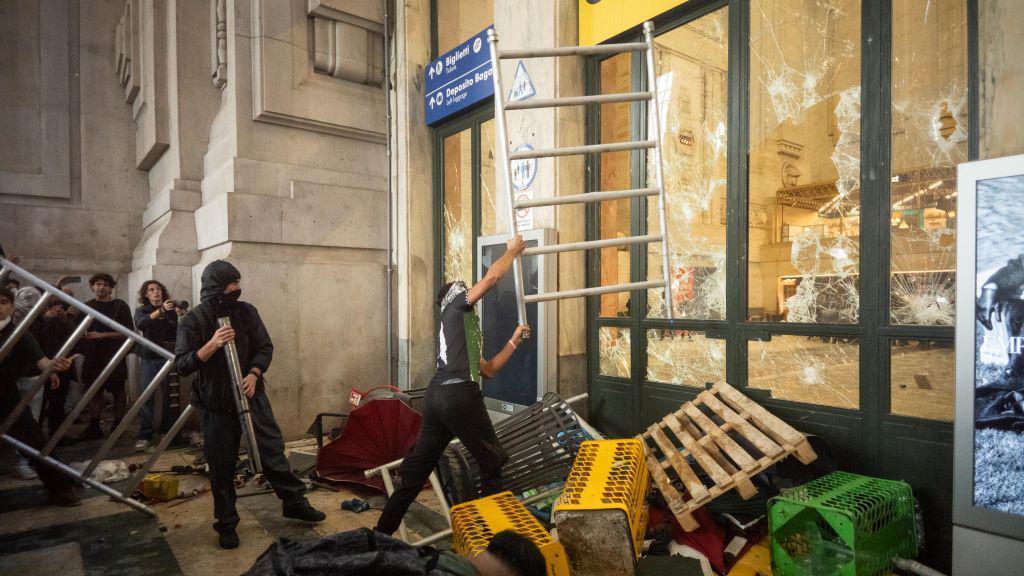 Sukobi demonstranata i policije na skupovima podrške Palestincima u Italiji 2 Maskirani muškarci razbijaju staklo na vratima metalnim gredama