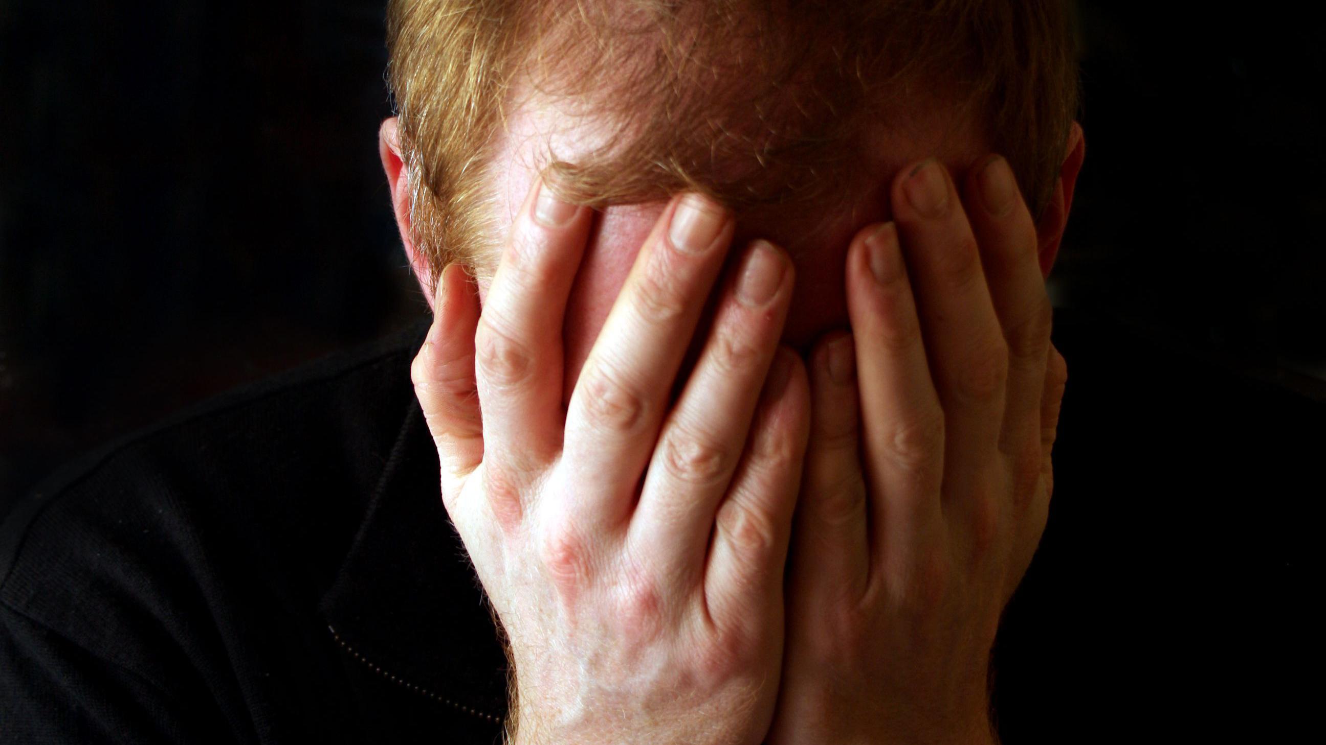 Opsesivno-kompulzivni poremećaj: Zarobljeni u mislima i ritualima 2 muškarac prekriva lice rukama, očajan muškarac