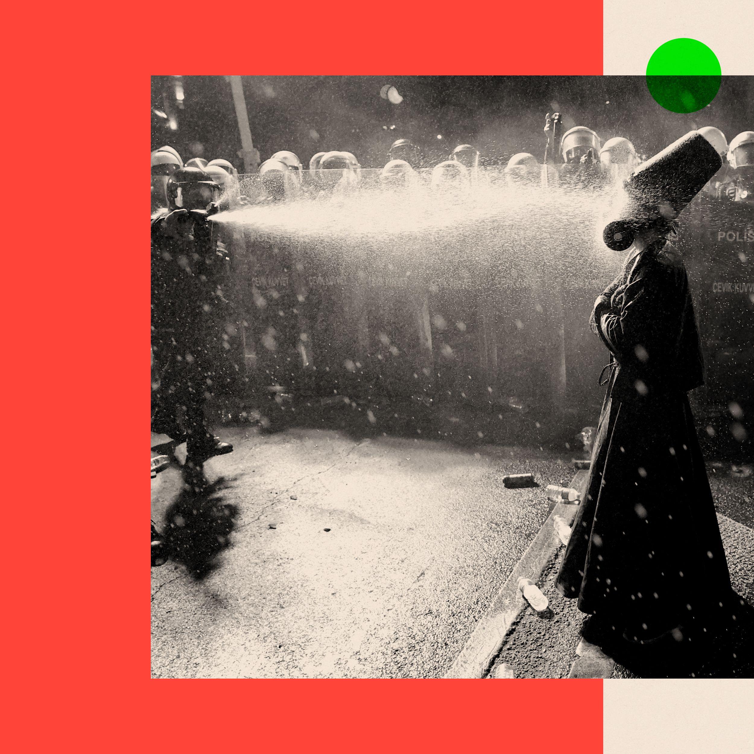 policija na ulicama prska biber sprej, protesti u turskoj, policajac prska biber sprejom momka obučenog u tradicionalnu, dervišku odoru