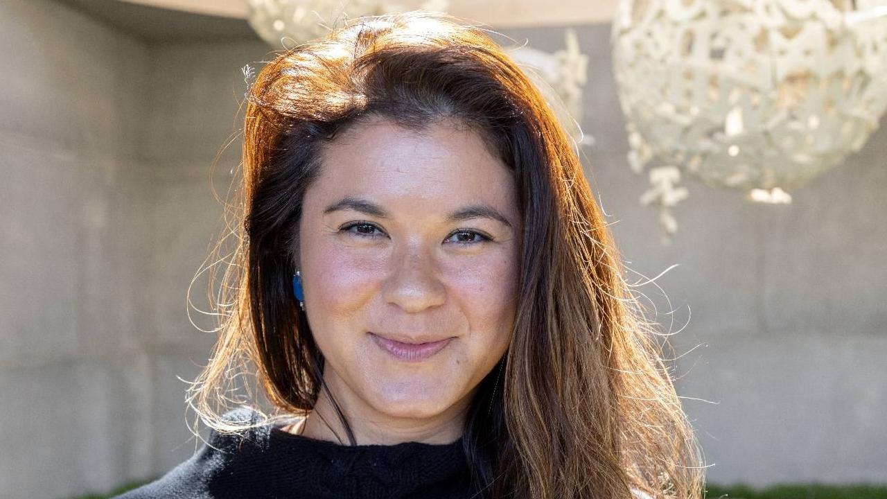 žena sa dugom braon kosom se osmehuje u kameru