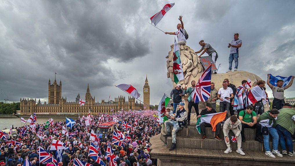 'Pošaljite ih kući': Šta se krije iza uspona nacionalizma u Velikoj Britaniji 1 Okupljeni mašu zastavama tokom skupa Ujedinite Kraljevstvo u blizini parlamenta 13. septembra 2025. u Londonu