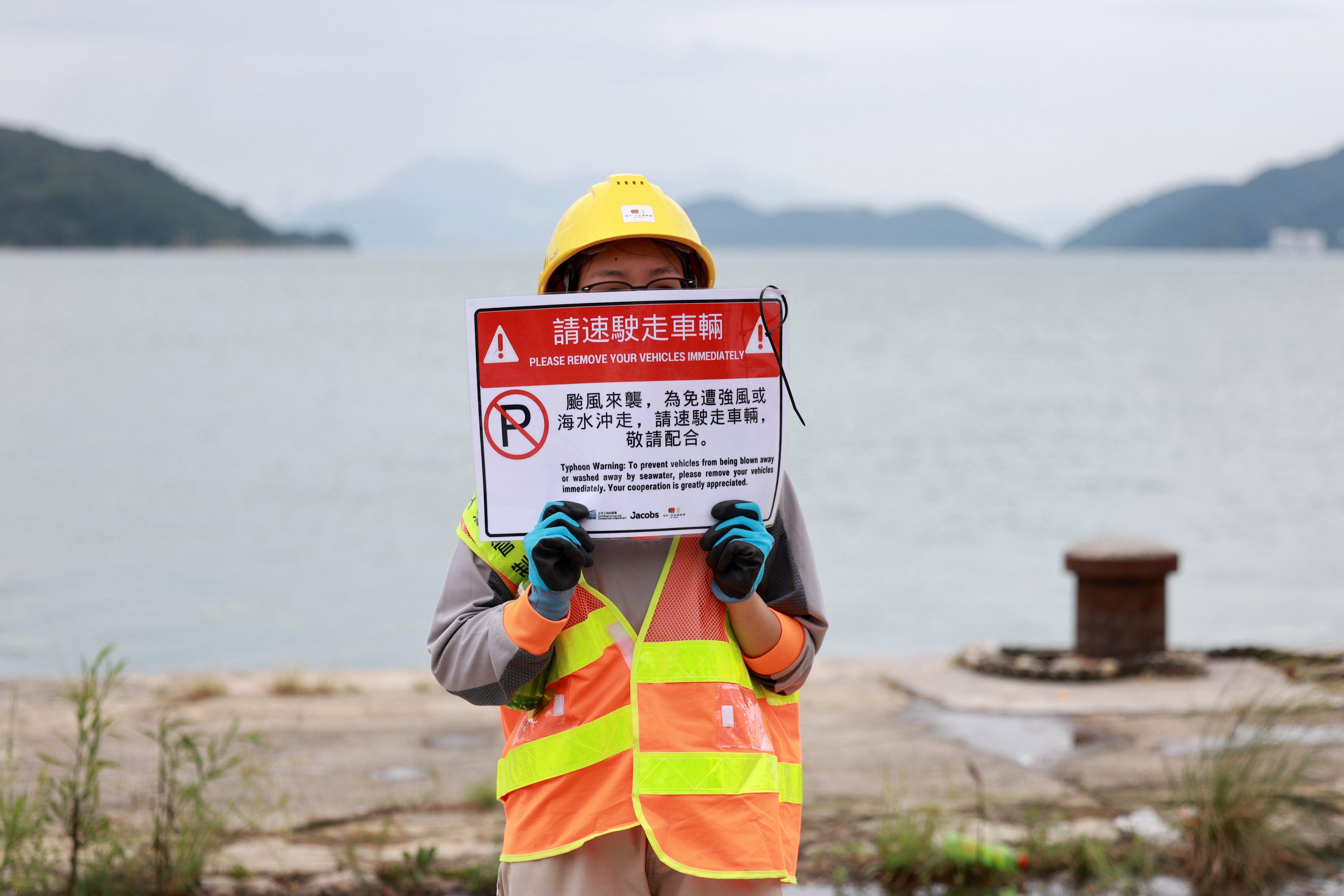 Dva miliona ljudi evakuisano u Kini zbog supertajfuna, na Tajvanu najmanje 14 poginulih 9 žena drži tablu sa upozorenjem na tajfun, žena drži tablu sa upozorenjem na nevreme