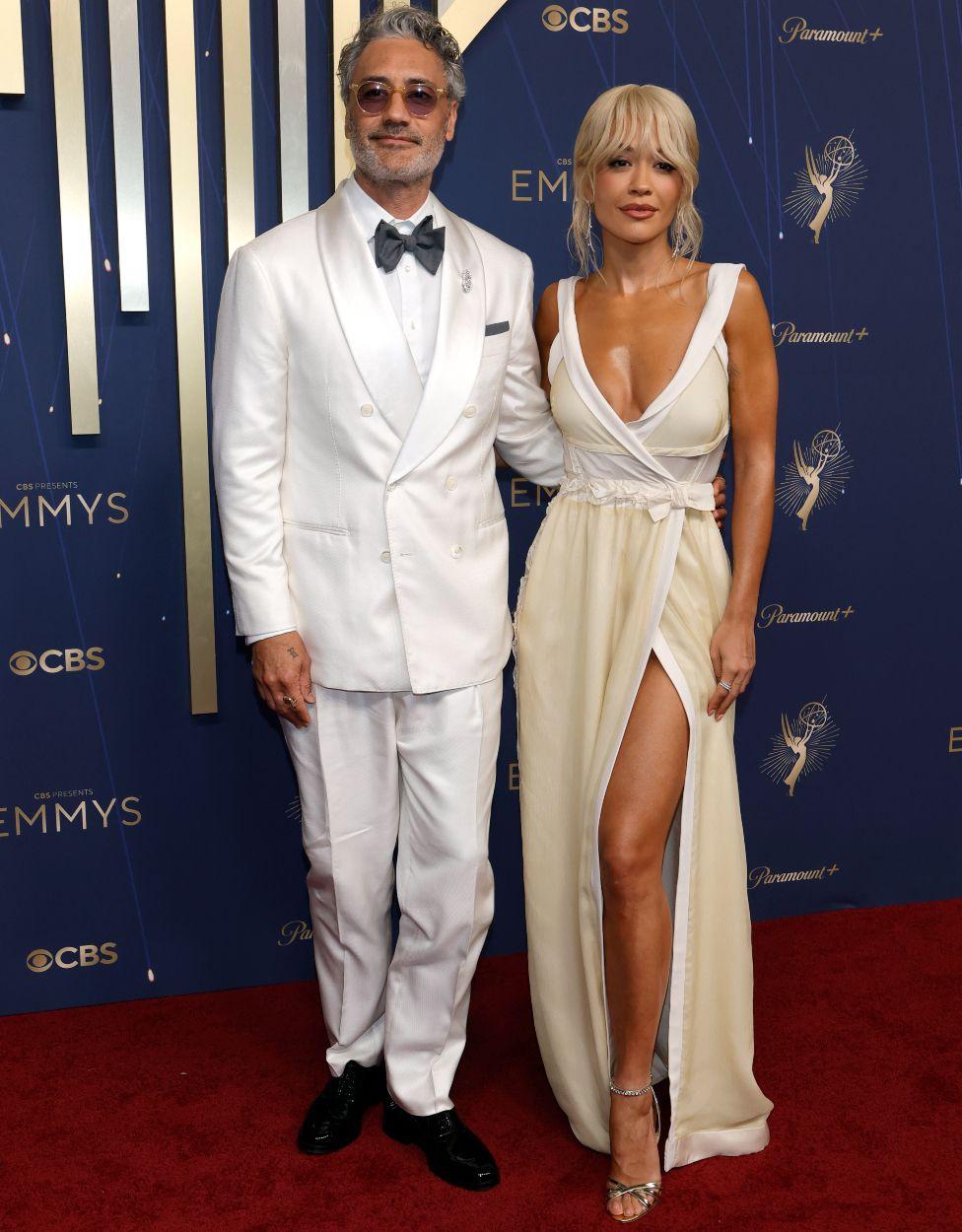 Reditelj Taika Vaititi u belom odelu sa suprugom pevačicom Ritom Orom u beloj haljini