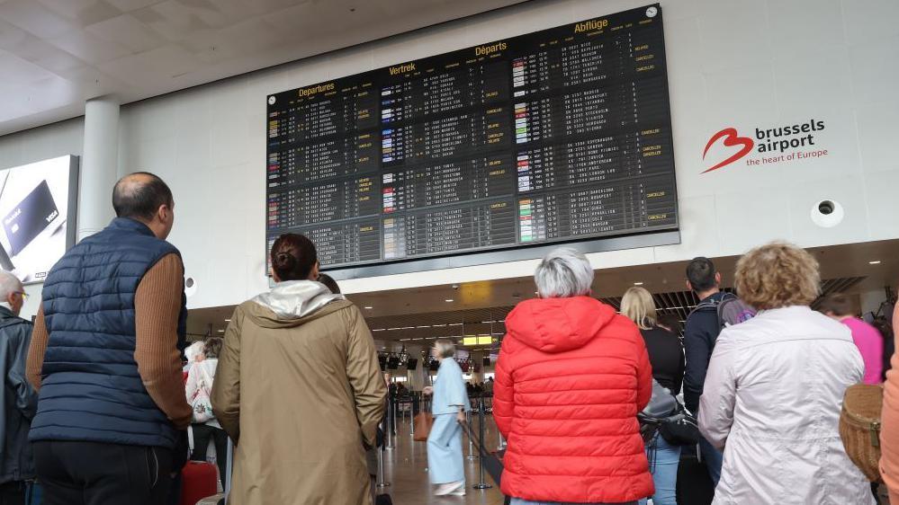 Kašnjenja na evropskim aerodromima: 'Sajber napad i ucene kriminalaca' 1 putnici gledaju u raspored letova na aerodromu u Briselu