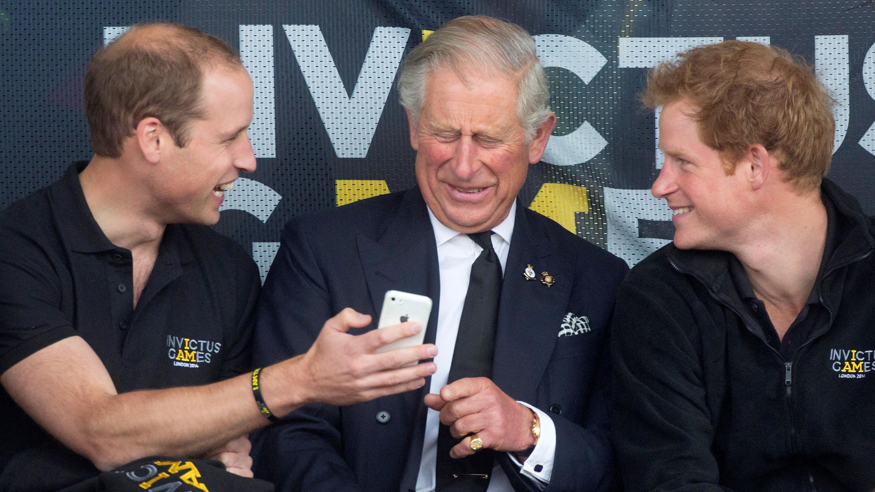 Princ Hari prvi put kod oca posle više od godinu dana 1 princ vilijam, kralj čarls, princ Hari, britanski prinčevi Vilijam (levo), Čarls (srednje) i Hari gledaju u mobilni telefon tokom Igara Nepokorenih
