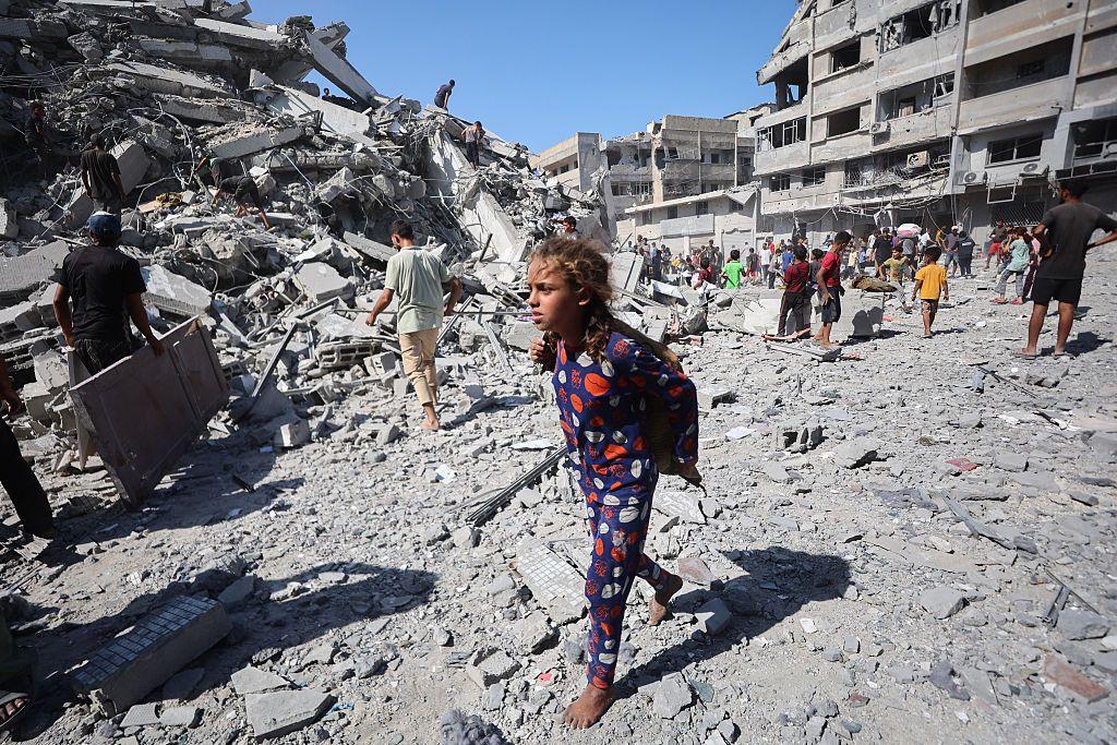 Fotogalerija: 'Gaza gori' u izraelskoj kopnenoj ofanzivi 7 Devojčica u šarenoj plavoj pidžami sa crvenim i belim crtežima hoda bosa po ruševinama dok raseljeni Palestinci spasavaju predmete iz ruševina kule Al-Gafri nakon što je uništena u izraelskim napadima.