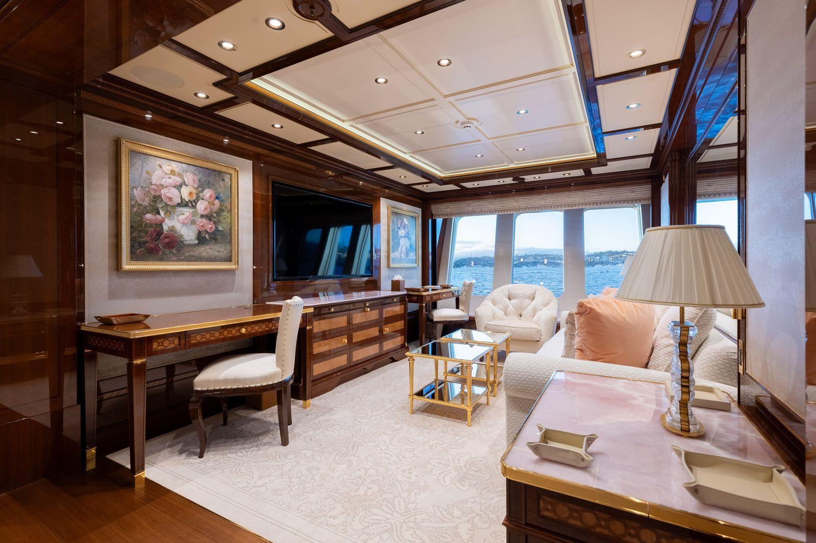 'Beskonačni' bazen, helidrom, osam soba: 'Superjahta ruskog milijardera' na aukciji 5 Jedna soba na superjahti Amadea opremljena je drvenim nameštajem, belim sofama i stolicom, televizorom i dvema cvetnim slikama. More i kopno se vide kroz prozore u pozadini.