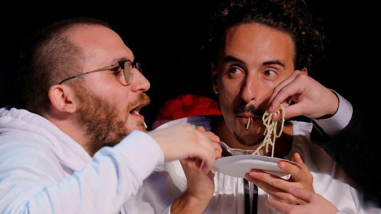 Dva muškarca jedu pastu na bini