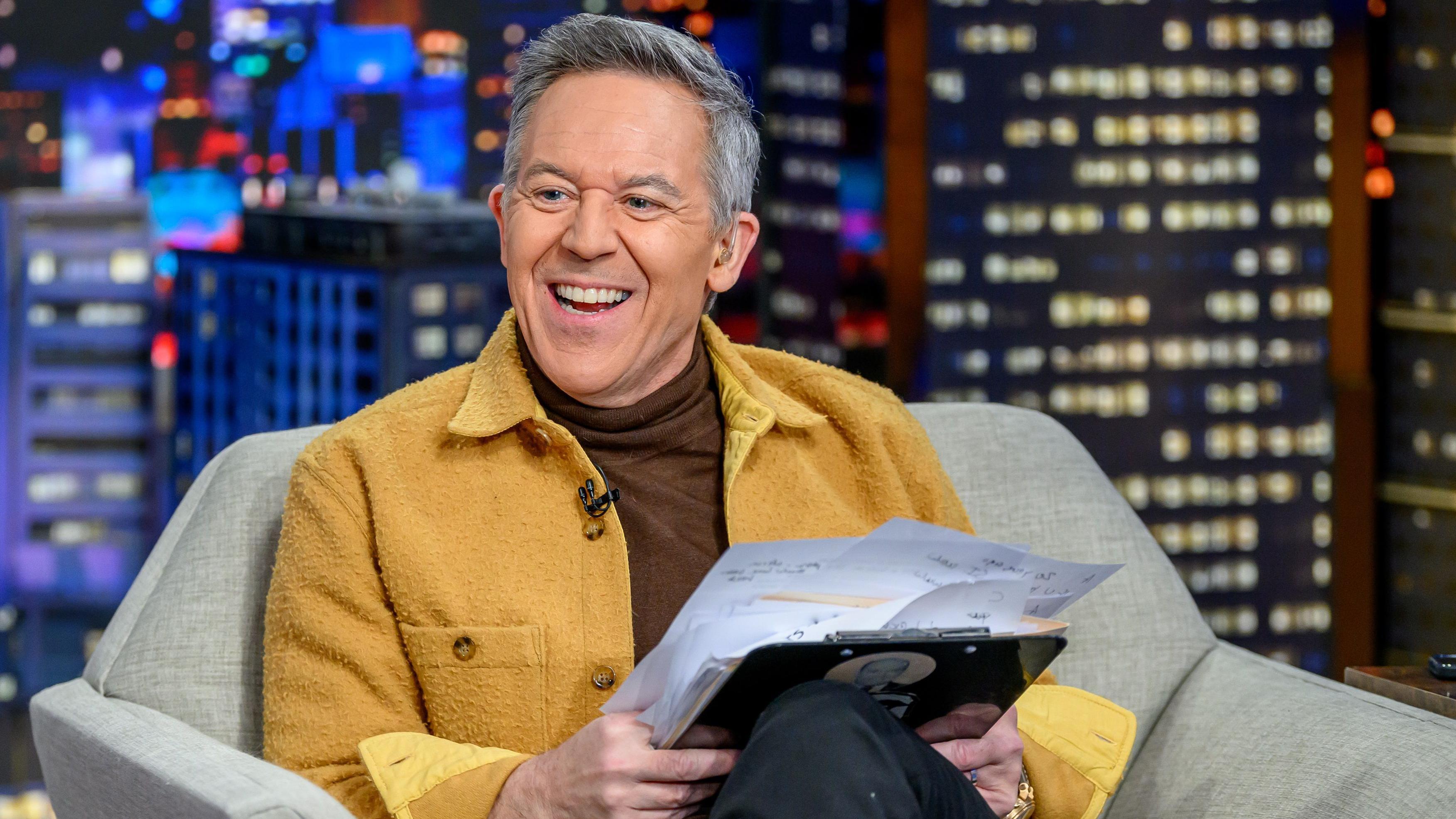 Podrška Džimiju Kimelu dok Tramp preti TV mrežama 5 Greg Gutfeld sitting in a chair and smiling against a nighttime cityscape backdrop on the set of his Fox News show