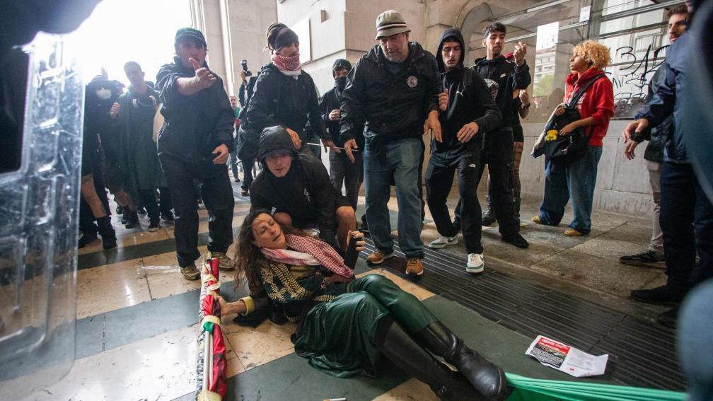 Sukobi demonstranata i policije na skupovima podrške Palestincima u Italiji 4 muškarac pokušava da podigne ženu koja je pala tokom protesta