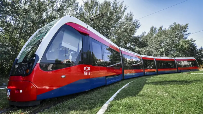 Kako je Beograd prešao put od 'konjskog' do modernih tramvaja 12 Savremeni tramvaj u bojama državne zastave Srbije okružen zelenilom