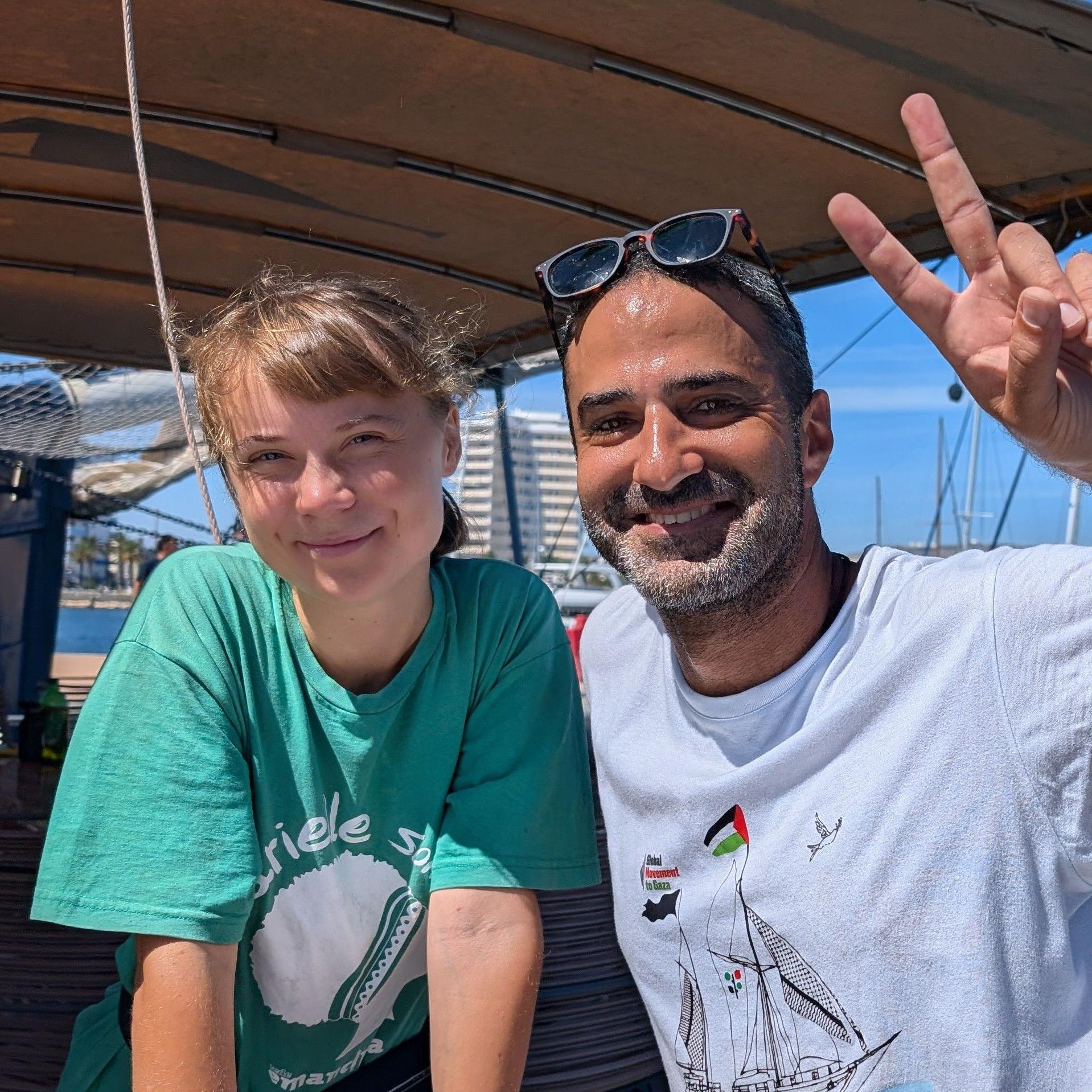 Šta je Sumud flotila i zašto je htela da dostavi pomoć Gazi morem kad Izrael ne da 4 Jusef Samour na brodu Julara sa klimatskom aktivistkinjom Gretom Tunberg - on podiže znak „v kao pobeda“ rukom i oboje se smeju.