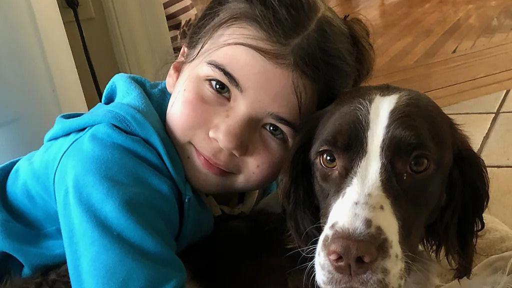 Devojčica u plavom duksu grli psa