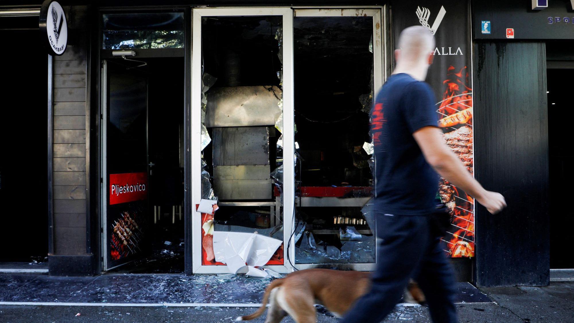 Napetosti u Crnoj Gori: Suspendovan bezvizni režim sa Turskom, privođenja zbog poziva na nasilje 1 Muškarac i pas prolaze pored zapaljenog kafića