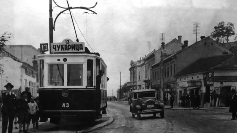 Kako je Beograd prešao put od 'konjskog' do modernih tramvaja 9 Tramvaj broj 13 na beogradskim ulicama, na crno beloj fotografiji, pored je jedan automobil, sa desne strane a sa leve ljudi