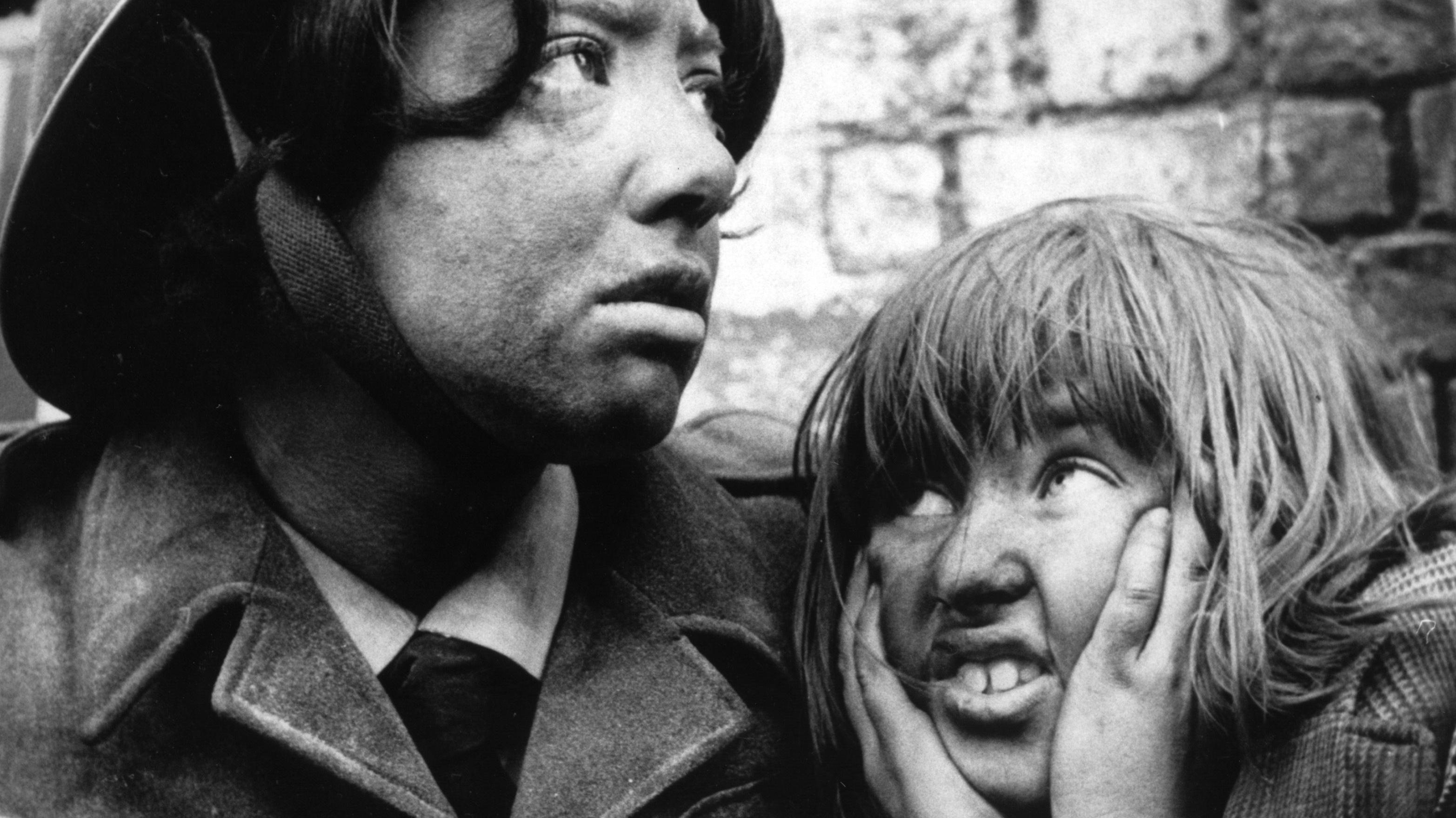 Film koji je osvojio Oskara uprkos tome što ga je BBC zabranio 1 Crno bela fotografija na kojoj su mlada žena u uniformi i devojčica koja rukama drži uši zatvorene. Lica obe deluju prljavo.