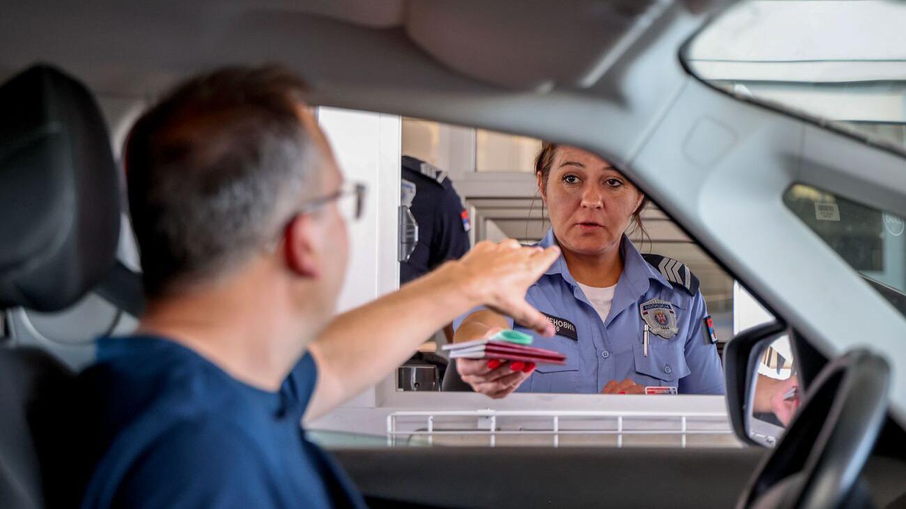Kako nisam ušla na Kosovo da izveštavam o izborima 2 Granična službenica u uniformi policije Srbije pruža dva srpska pasoša čoveku koji je pružio ruku krou prozor automobila