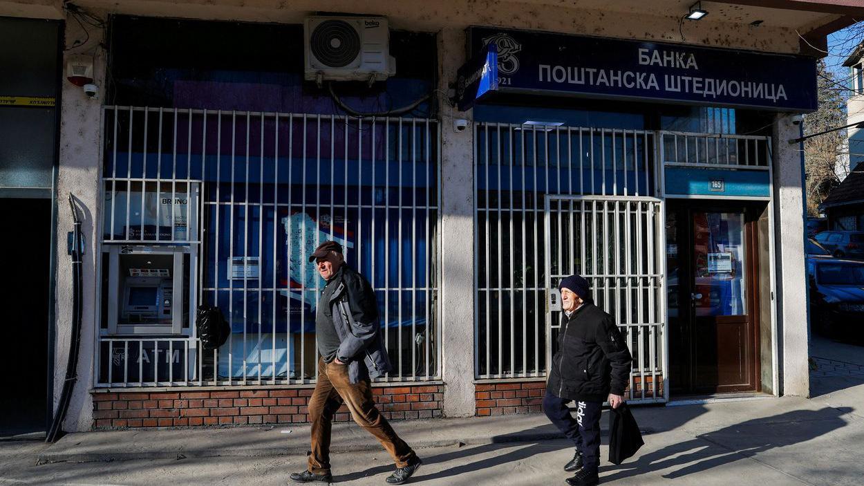 Lokalni izbori na Kosovu: Mogu li Srbi da se vrate u institucije 5 Dva starija muškarca ispred Banke poštanske štedionice u Severnoj Mitrovici