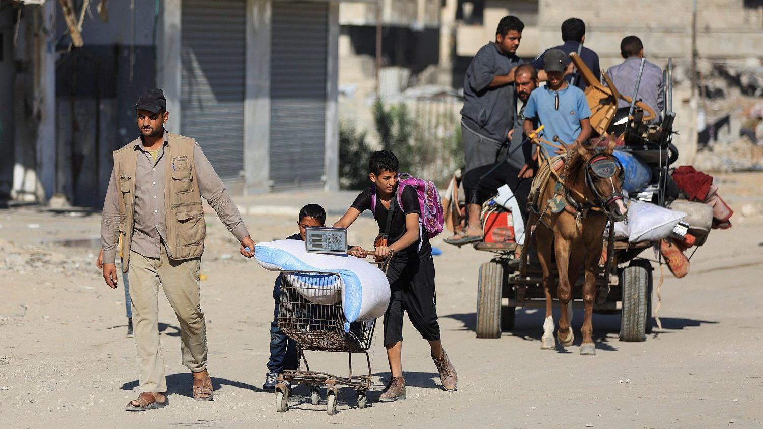 Vraćena još četiri tela talaca, Tramp preti Hamasu: „Ako nećete sami, mi ćemo vas razoružati" 1 Palestinians, with their belongings, move along a street, amid a ceasefire between Israel and Hamas, in Gaza City, October 15, 2025. REUTERS/Dawoud Abu Alkas