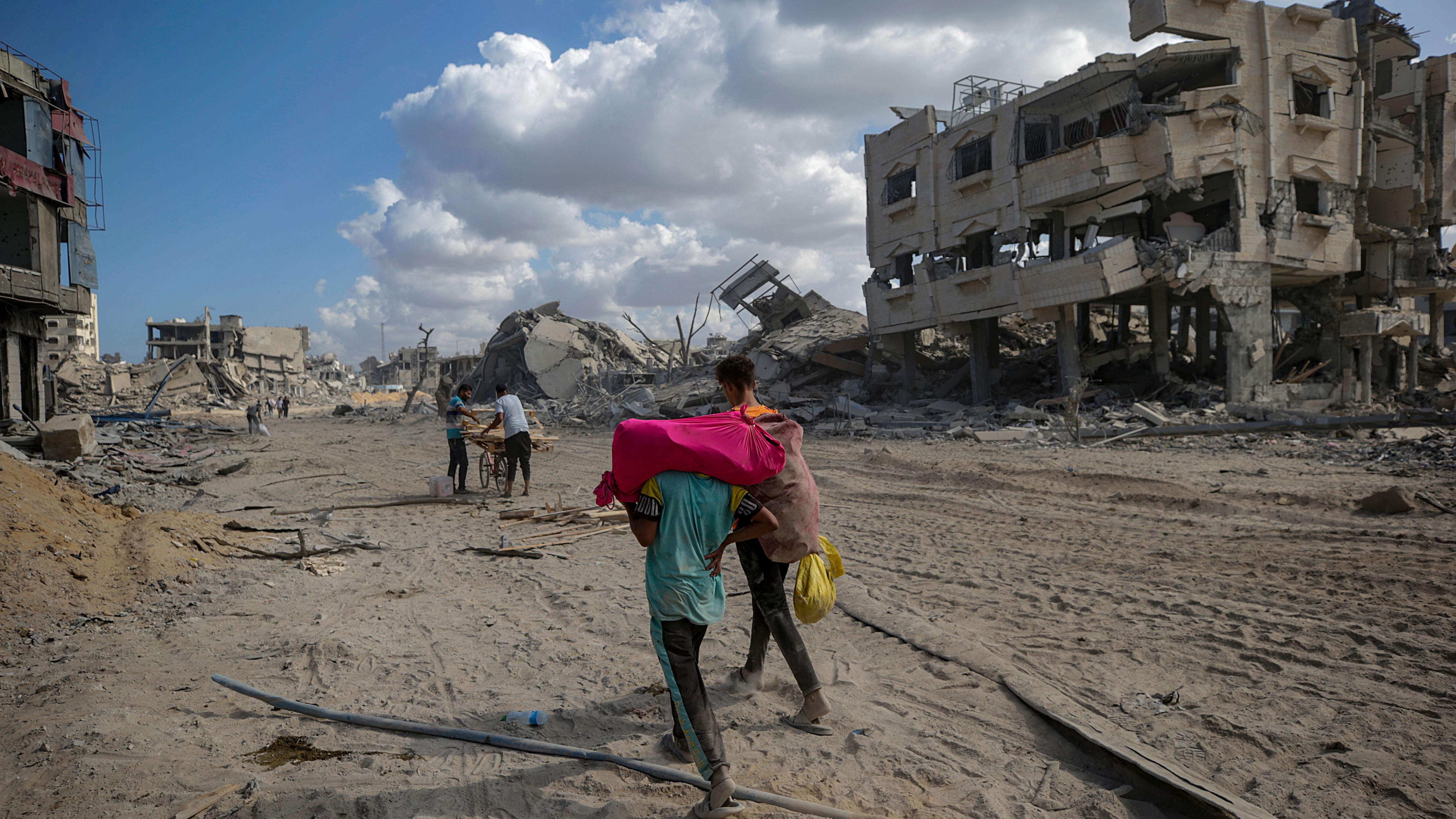 Palestinci se vraćaju na sever Gaze, prekid vatre stupio na snagu, tvrdi Izrael 3 Palestinians, who were displaced to the southern part of Gaza at Israel's order during the war, make their way following their arrival in Gaza City