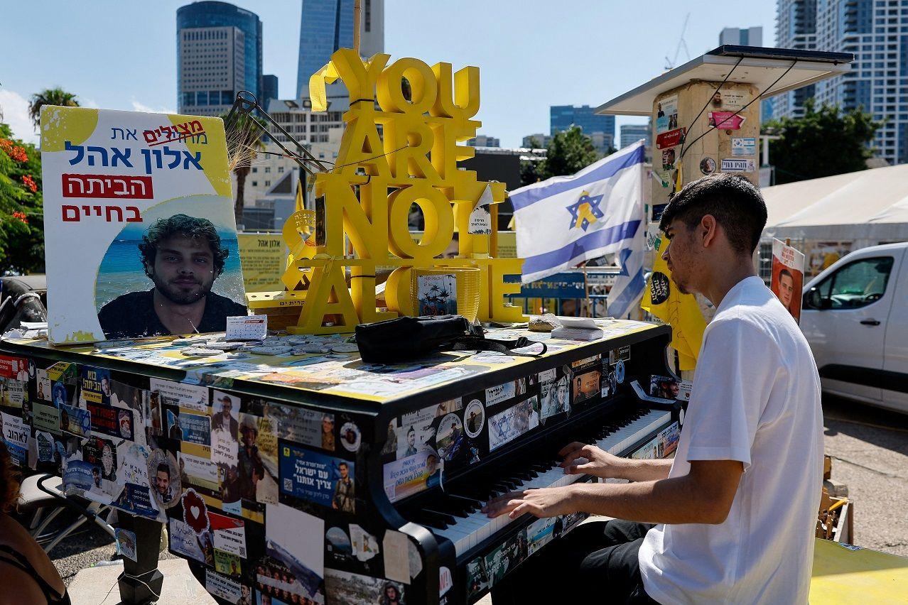 Desetine kamiona pomoći ulaze u Gazu, Hamas traži oslobađanje poznatih zatvorenika 5 A boy plays the piano at "Hostages Square", after a ceasefire between Israel and Hamas in Gaza went into effect, in Tel Aviv, Israel