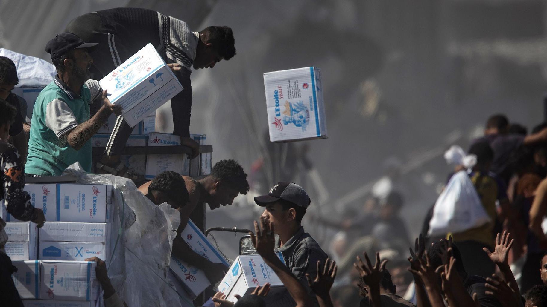 Desetine kamiona pomoći ulaze u Gazu, Izrael se sprema za prihvat talaca 1 Muškarci sa kamiona bacaju humanitarnu pomoć stanovništvu Gaze