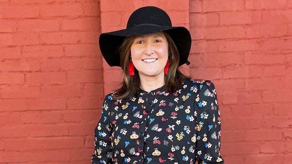 Nova nada: Ove vakcine bi mogle da zaustave rak dojke 5 Slika Dajane Ines - nosi veliki crni šešir sa širokim nogavicama i crvene viseće minđuše, sa crnom šarenom haljinom-košuljom. Stoji ispred zida od cigle